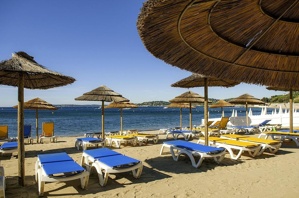Photo de l'hotel des Issambres verideon, transat sur le sable avec vue sur la mer et parasol en paille